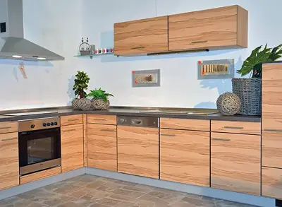 Küche mit Holzfronten, schwarzer Arbeitsplatte, Backofen und Hängeschrank